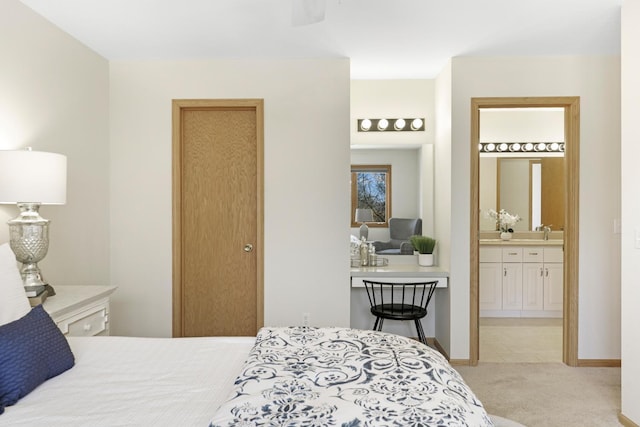 bedroom with a sink, ensuite bath, baseboards, and carpet floors