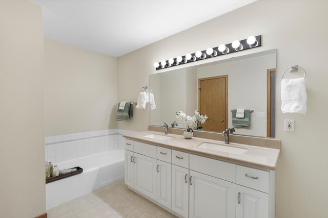 full bathroom featuring double vanity, a bath, tile patterned floors, and a sink