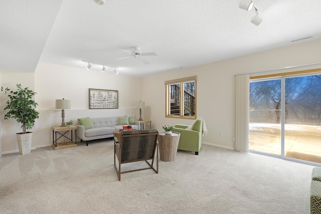 living room with light carpet, plenty of natural light, and a textured ceiling