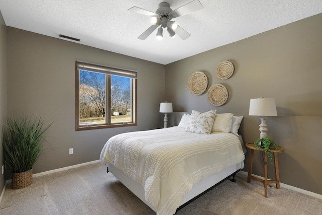 carpeted bedroom with visible vents, baseboards, a textured ceiling, and ceiling fan