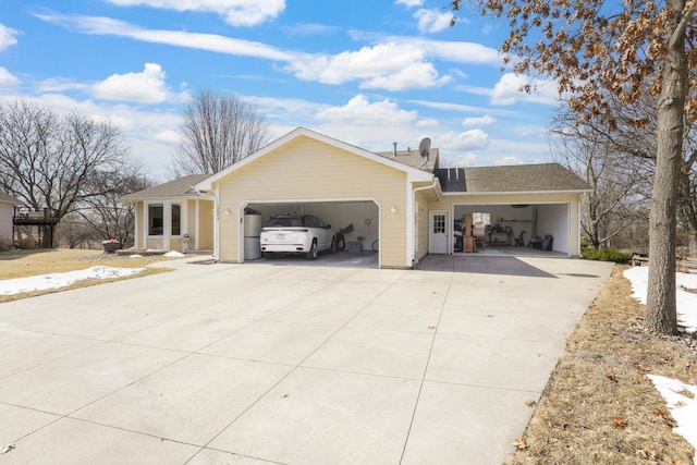 view of front of home featuring concrete driveway, an attached garage, and roof with shingles