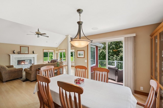 5191 Christen Ave NE, Buffalo, MN 55313 - dining area with baseboards, vaulted ceiling, light wood-style floors, a glass covered fireplace, and a ceiling fan
