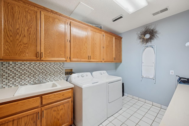 5191 Christen Ave NE, Buffalo, MN 55313 - washroom featuring visible vents, a sink, cabinet space, separate washer and dryer, and light tile patterned floors