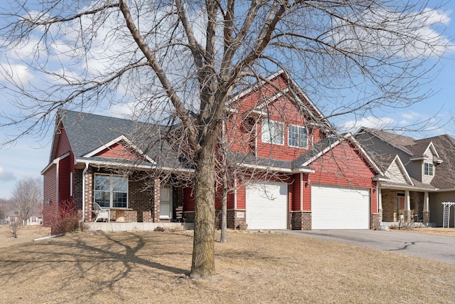 craftsman house featuring roof with shingles, driveway, a porch, a front lawn, and brick siding