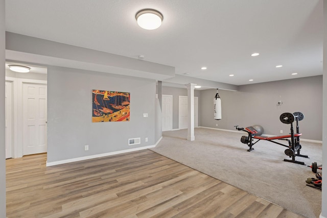 workout room featuring recessed lighting, baseboards, visible vents, and light wood-type flooring