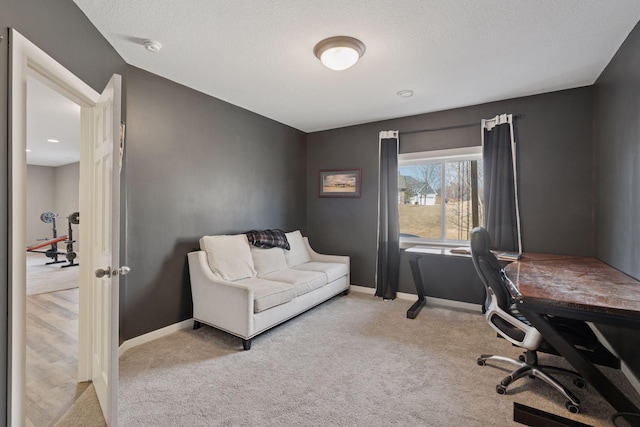 office area with carpet, baseboards, and a textured ceiling