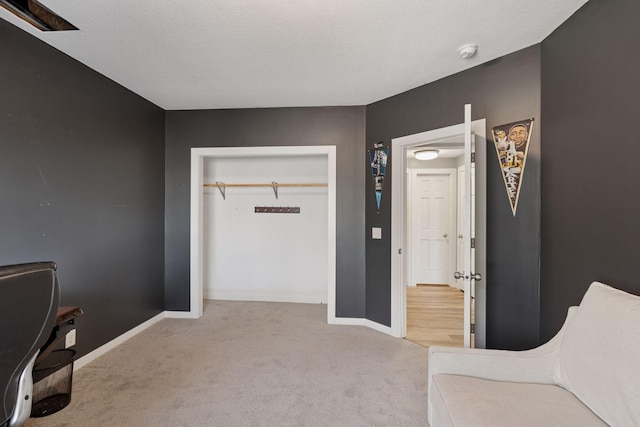 carpeted bedroom with a closet, baseboards, and a textured ceiling