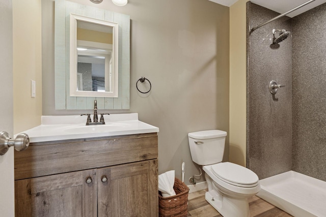 full bath featuring vanity, toilet, wood finished floors, and a stall shower