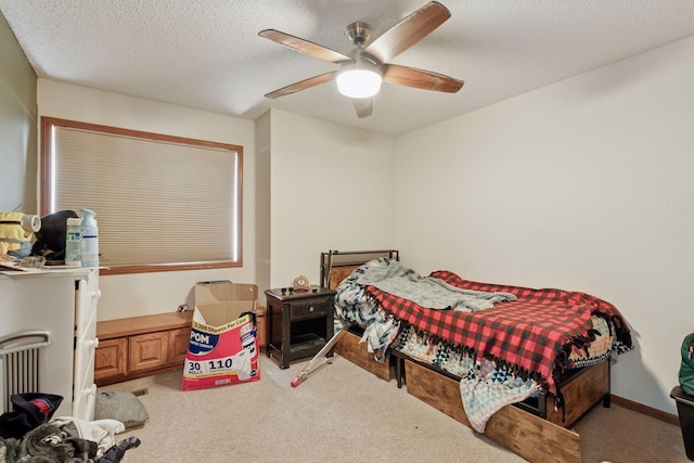 carpeted bedroom with a ceiling fan, baseboards, and a textured ceiling