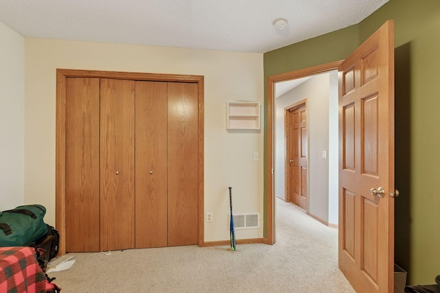 bedroom with baseboards, visible vents, a closet, a textured ceiling, and carpet flooring