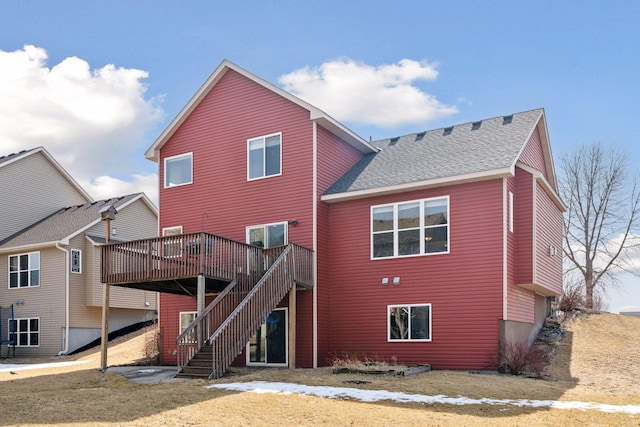 back of property with roof with shingles, a deck, and stairs