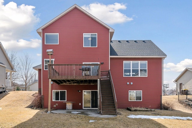 rear view of house featuring stairway, a patio area, a wooden deck, and a shingled roof