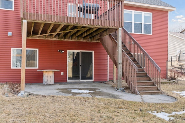 back of house featuring a patio, roof with shingles, and stairs