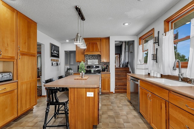 kitchen with backsplash, a kitchen island, appliances with stainless steel finishes, a kitchen breakfast bar, and a sink