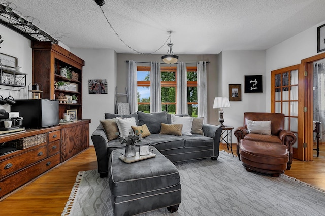 living area with a textured ceiling and wood finished floors