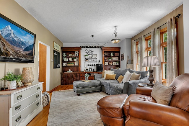 living area with light wood-type flooring and a textured ceiling