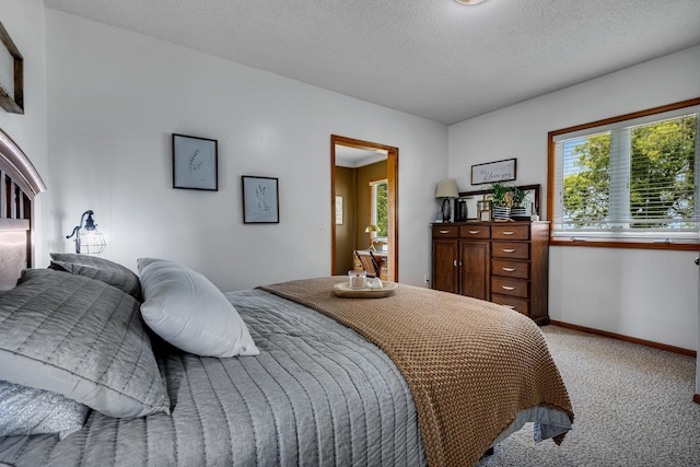 bedroom with light carpet, a textured ceiling, and baseboards