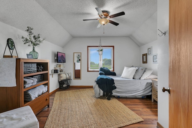 bedroom featuring vaulted ceiling, a textured ceiling, a ceiling fan, and wood finished floors