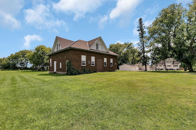 view of side of home with brick siding and a lawn