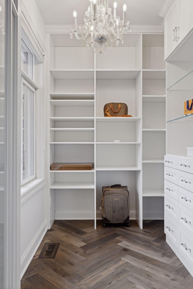 walk in closet with a chandelier, visible vents, and parquet floors