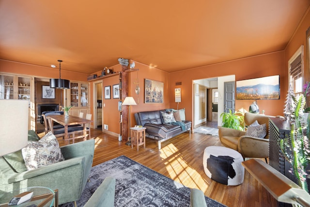 living area with visible vents, wood finished floors, and a fireplace