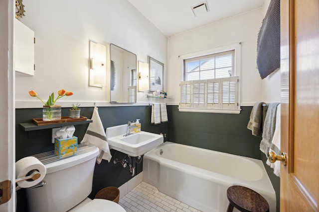 full bath featuring a bath, visible vents, a sink, tile patterned flooring, and toilet