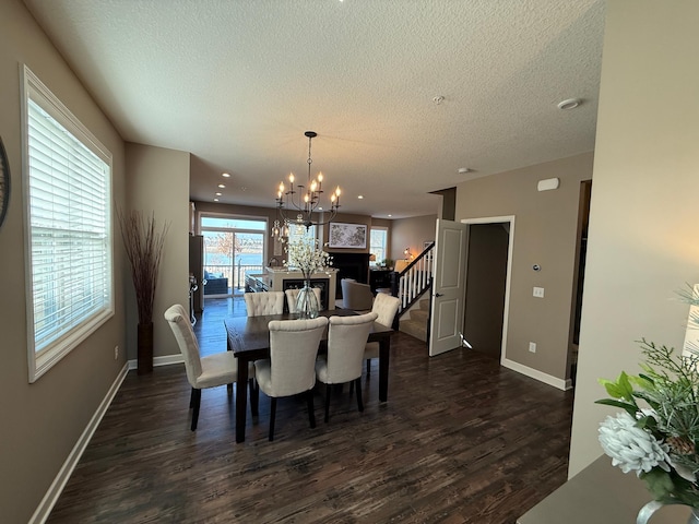 dining space with stairway, baseboards, an inviting chandelier, dark wood-style flooring, and a textured ceiling