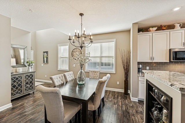 dining space with dark wood-type flooring, beverage cooler, baseboards, and a chandelier