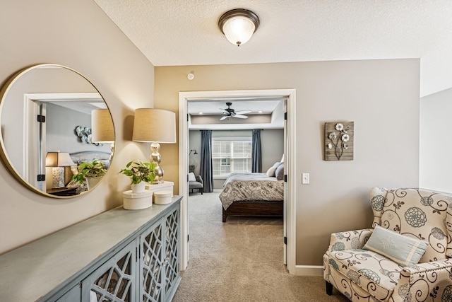 bedroom with light colored carpet, a textured ceiling, and baseboards