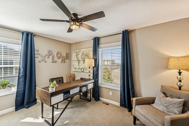 home office with plenty of natural light, a ceiling fan, and light carpet