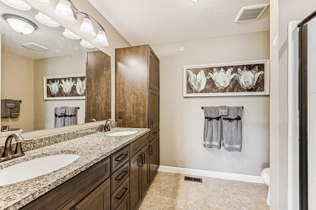 full bathroom featuring a textured ceiling, visible vents, and a sink