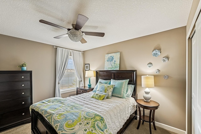 bedroom with a textured ceiling, a closet, carpet floors, baseboards, and ceiling fan