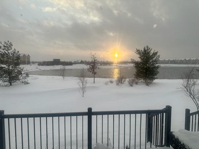 yard layered in snow featuring a water view