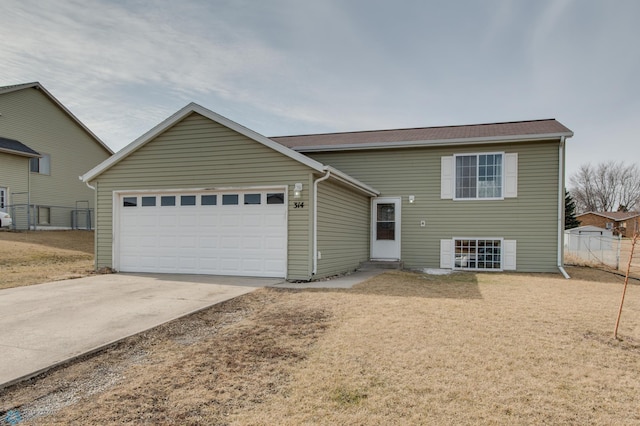 tri-level home featuring fence, a garage, and driveway