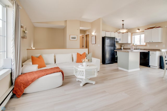 living area with a baseboard radiator, light wood-style flooring, and vaulted ceiling