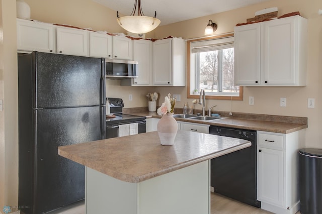 kitchen featuring a center island, hanging light fixtures, white cabinets, black appliances, and a sink