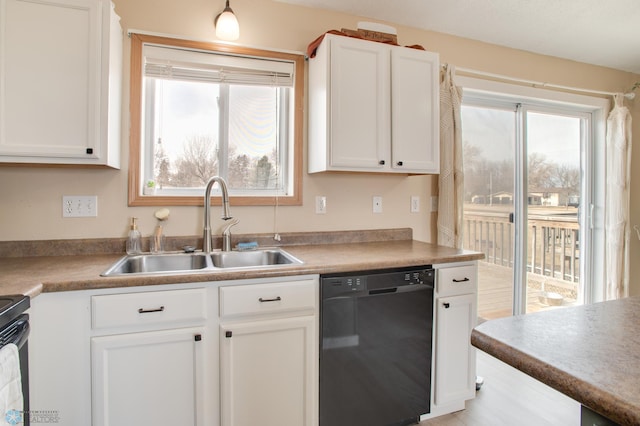 kitchen with white cabinets, dishwasher, light countertops, and a sink