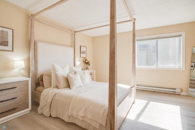 bedroom featuring light wood-style floors and a baseboard radiator