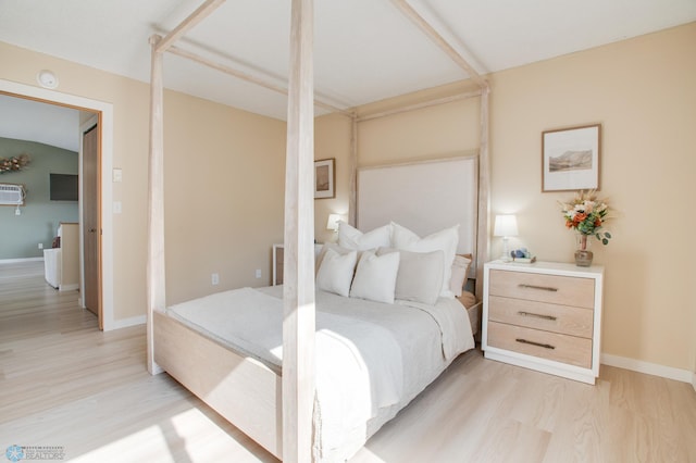 bedroom featuring light wood finished floors and baseboards