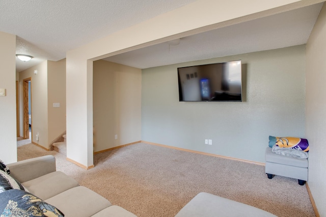 living room featuring baseboards, carpet, stairs, and a textured ceiling