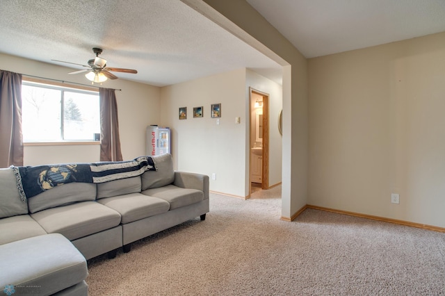 living room featuring light carpet, a textured ceiling, baseboards, and a ceiling fan