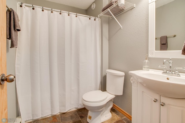 bathroom with a shower with curtain, toilet, baseboards, vanity, and a textured wall