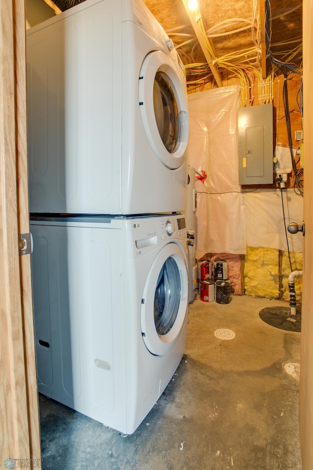 laundry area with electric panel, stacked washer and clothes dryer, and laundry area