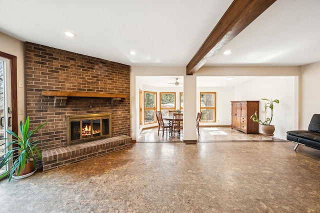 living area featuring a fireplace, beamed ceiling, recessed lighting, and baseboards