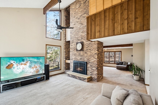 living area featuring beam ceiling, carpet, and a healthy amount of sunlight