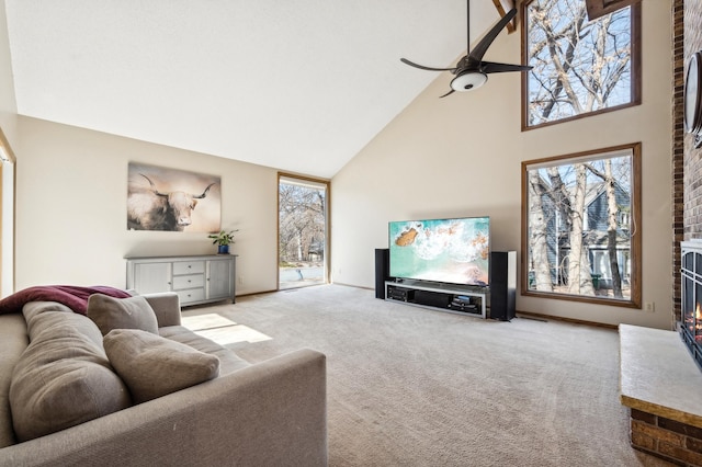 living area with a brick fireplace, carpet floors, high vaulted ceiling, and a healthy amount of sunlight