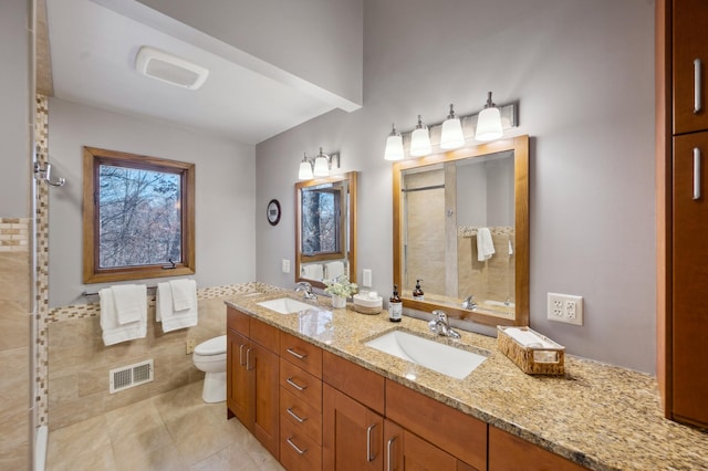 bathroom with a sink, visible vents, toilet, and a tile shower