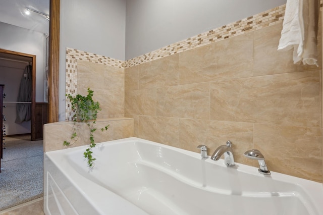 bathroom featuring tile walls and a garden tub