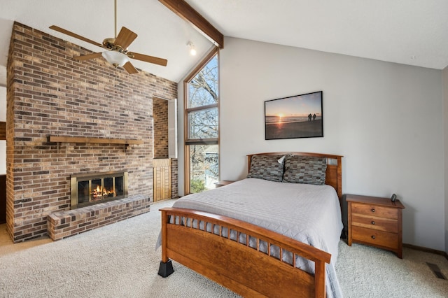 carpeted bedroom featuring visible vents, high vaulted ceiling, a fireplace, ceiling fan, and beamed ceiling