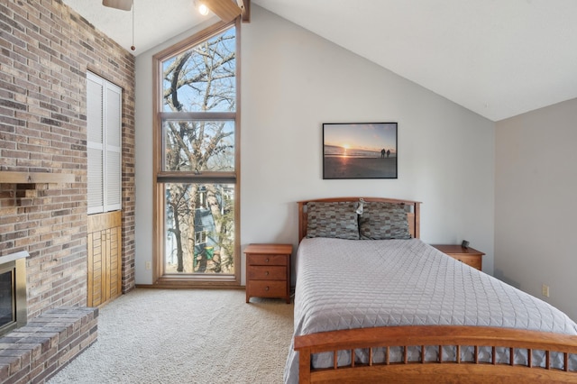 bedroom with brick wall, lofted ceiling with beams, carpet flooring, a fireplace, and a ceiling fan